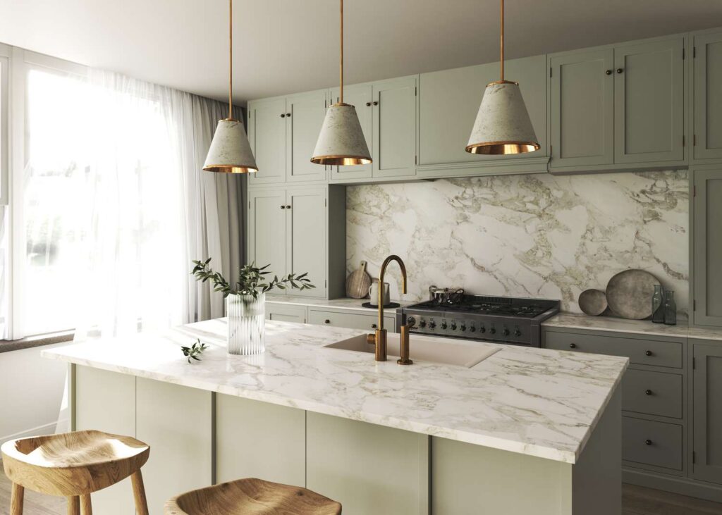 Modern sage green kitchen featuring a marble backsplash and island countertop, pendant lights, and natural wooden stools.