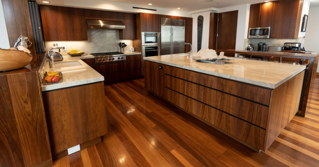 Modern kitchen with rich walnut wood veneer cabinets, marble countertops, and stainless steel appliances