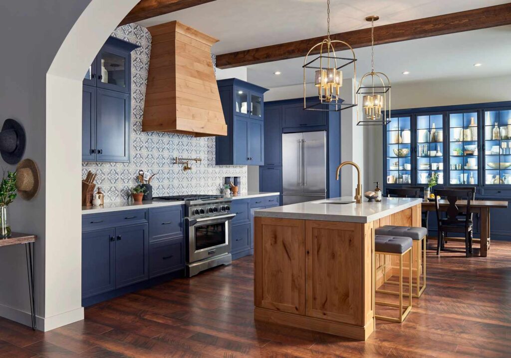 Elegant kitchen with navy blue cabinets, wood island, patterned backsplash, and pendant lighting