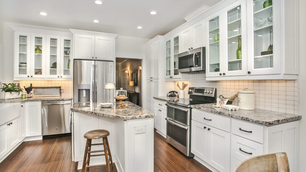 Contemporary kitchen with white shaker cabinets, granite countertops, and stainless steel appliances