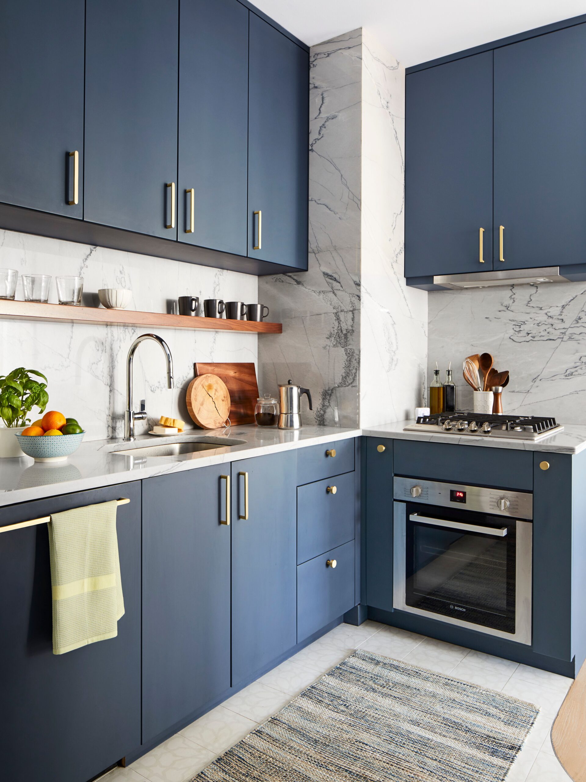 Modern kitchen with navy blue cabinets and marble backsplash