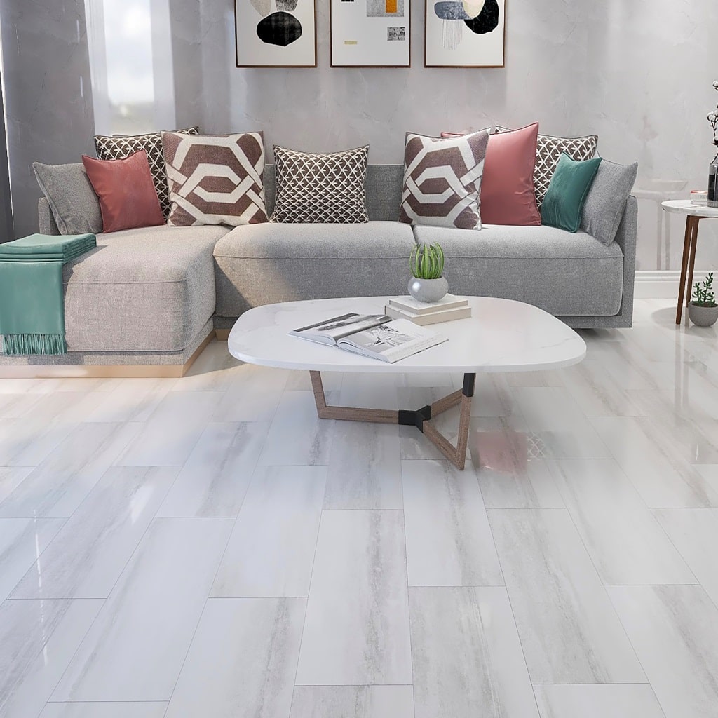 Modern living room with white stone-effect vinyl tile flooring, gray sectional sofa, and geometric pillows.