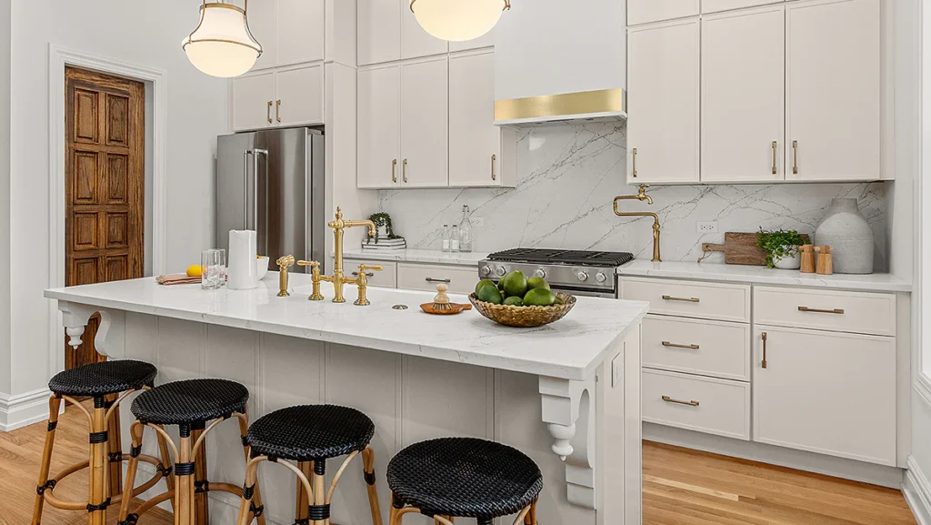 Elegant white kitchen with gold fixtures and marble countertops