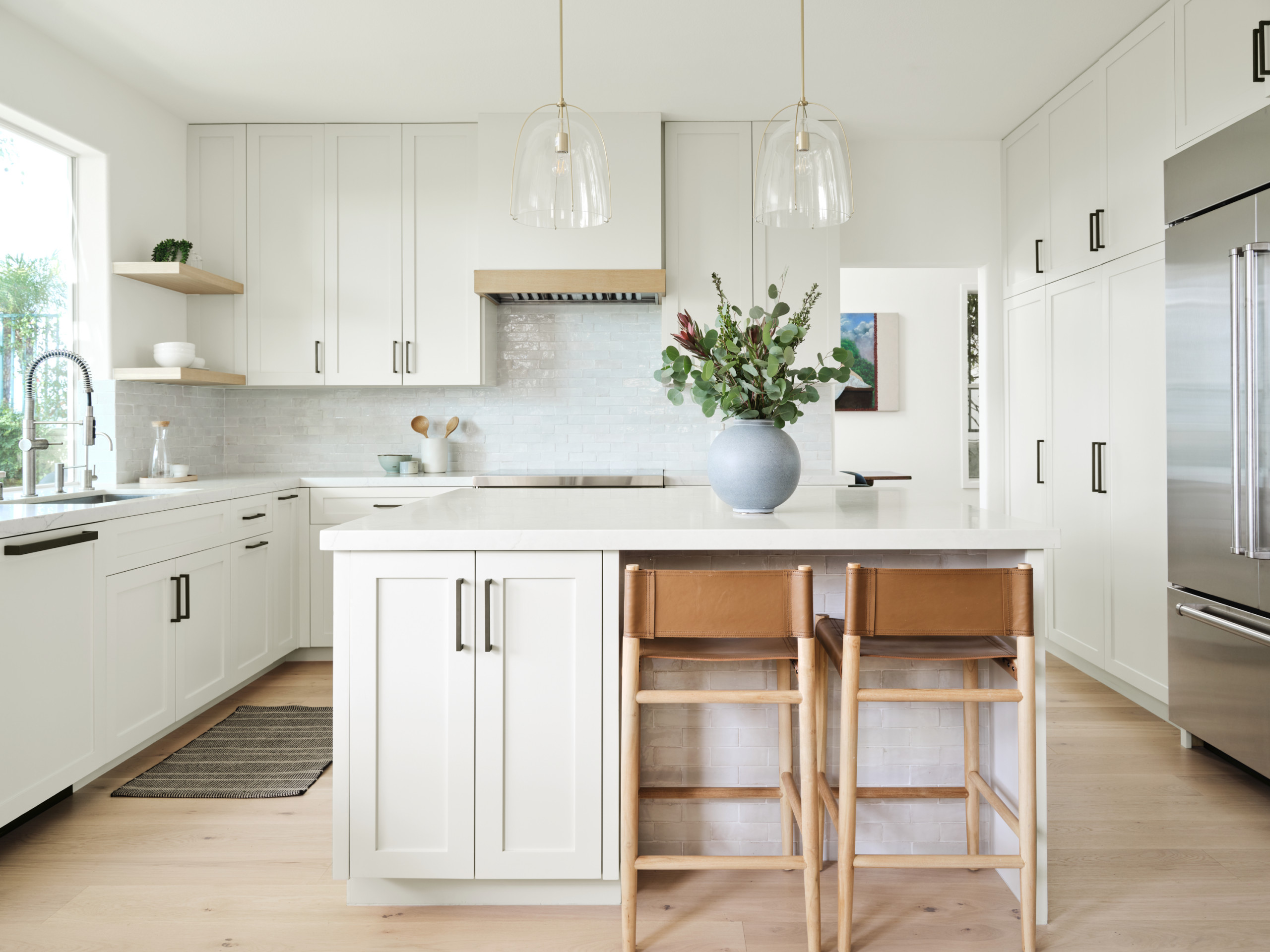 Modern white kitchen with shaker cabinets and island seating