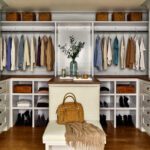 Spacious walk-in closet with custom cabinetry, seating, and organized storage