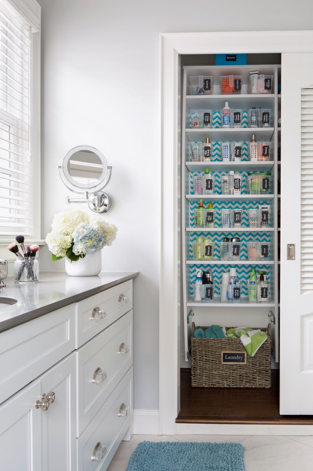 Organized bathroom storage closet with labeled baskets and toiletries