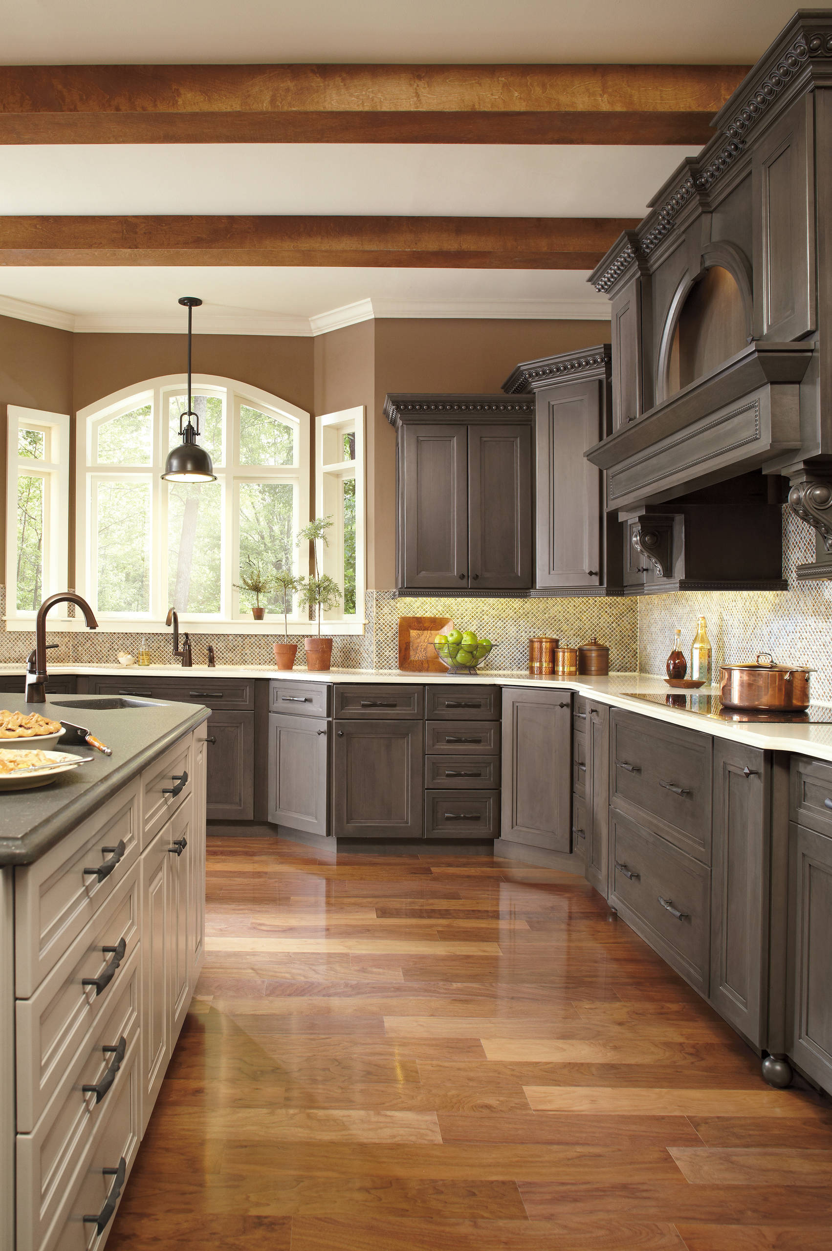 Traditional kitchen with dark wood cabinets, large windows, and warm hardwood floors.
